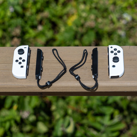White Nintendo Switch Joy-Con L and R wireless controller pair with wrist straps