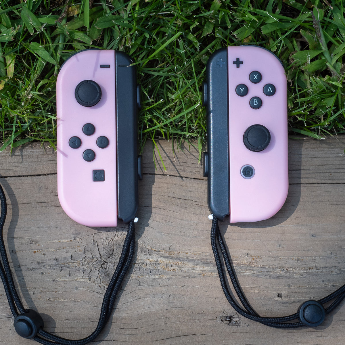 Pastel pink Nintendo Switch Joy-Con L and R wireless controller pair with wrist straps