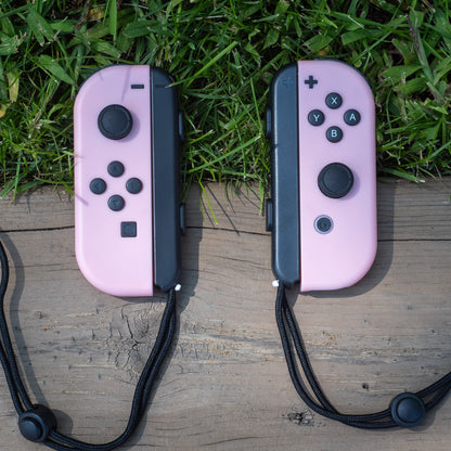Pastel pink Nintendo Switch Joy-Con L and R wireless controller pair with wrist straps