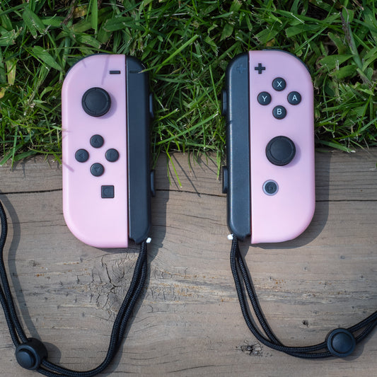 Pastel pink Nintendo Switch Joy-Con L and R wireless controller pair with wrist straps