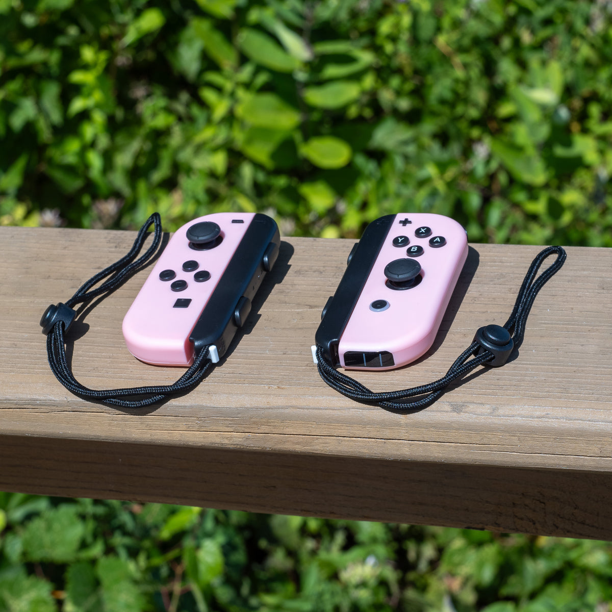Pastel pink Nintendo Switch Joy-Con L and R wireless controller pair with wrist straps