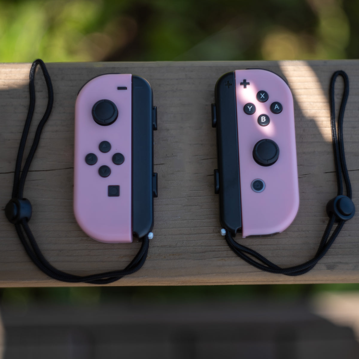 Pastel pink Nintendo Switch Joy-Con L and R wireless controller pair with wrist straps